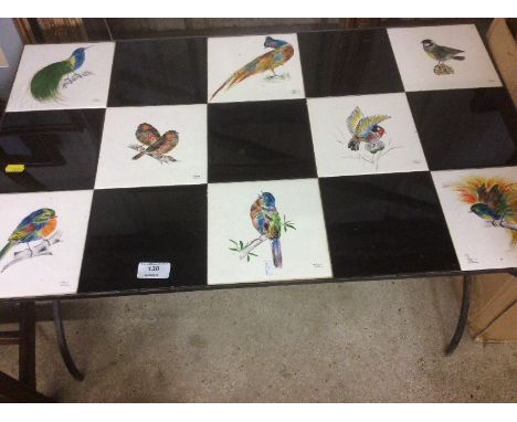 A tile top coffee table decorated with birds