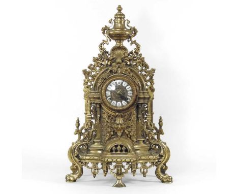 An ornate French gilt metal mantel clock, 20th century, decorated with scrolls, 61cm high