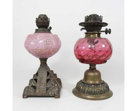A Victorian oil lamp base, with a ruby glass reservoir, 32cm high, together with another with a pink glass reservoir (2)