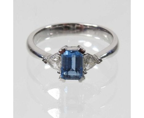 An 18 carat gold diamond and aquamarine ring, the central baguette stone flanked by two trillion cut diamonds, 3.5g, size M