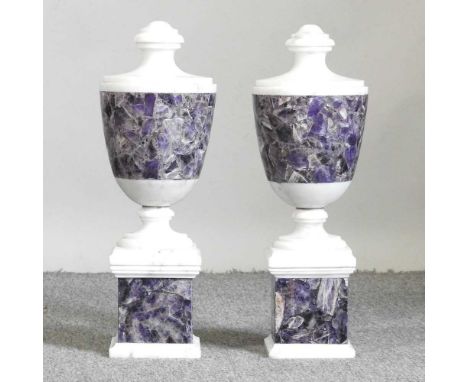 A pair of white marble and purple hardstone urns, 20th century, each of baluster shape, on a plinth base, 45cm highDirty with