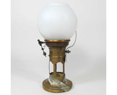 A brass wind up clockwork night light/clock, with an associated glass shade, 23cm high. This would have originally had a shad