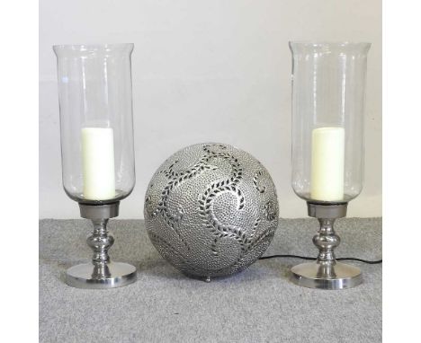 A pair of storm lanterns, 33cm high, and a silver painted ball shaped lamp (3)