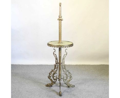 An ornate brass and green onyx standard lamp, on an ornate scrolled base, with dolphin feet, 142cm high