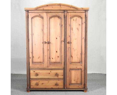 A modern pine triple wardrobe, with spirally turned columns and drawers below140w x 58d x 200h cmOverall solid, clean and usa