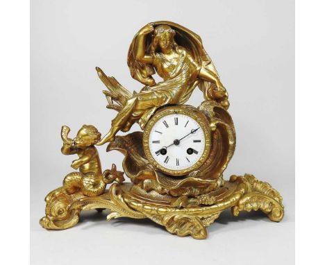 A late 19th century continental gilt metal figural mantel clock, surmounted by a young lady and a cherub, having a white enam