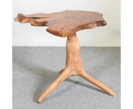 A rustic yew wood tripod table, with a tree trunk top, on a rootwood base70w x 62d x 64h cm