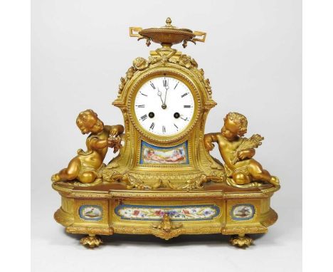 A 19th century French ormolu figural mantel clock, inset with Sevres style porcelain plaques and surmounted by cherubs, havin
