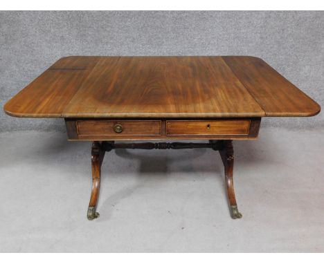 A Regency mahogany sofa table with twin drop flaps on stretchered swept supports terminating in brass cap casters. H.71 W.140