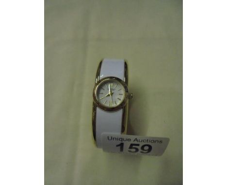 A Caravelle New York white enamel bangle watch.