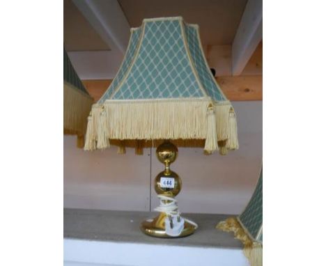 A good quality brass table lamp with fringed shade.The shade is in good condition