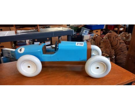 A large wooden model of a 1930's racing car in the style of a Bugatti
