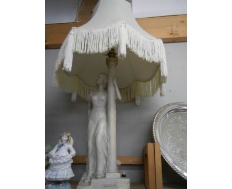 A tall plaster figural table lamp with shade.