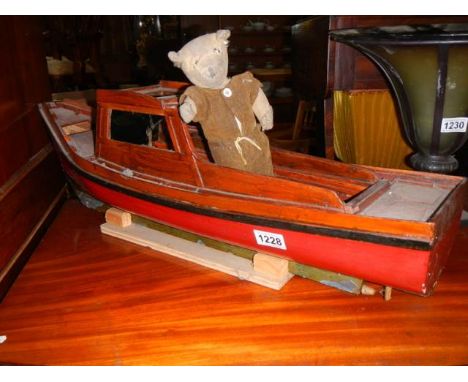 A model boat with and old Teddy bear.