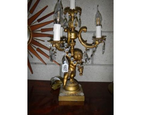 An early 20th century candelabra style table lamp supported by a cherub.