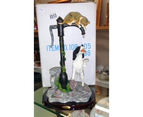 A large sculpture of a spaniel and tabby cat playing with/on a tap1 leaf on vine on pump is chipped can't see any other damag