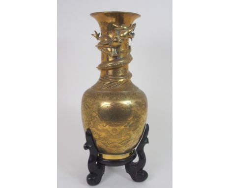 A CHINESE BRASS BALUSTER VASE cast with a dtragon wraped around the neck and above panels of dragons and precious objects, se