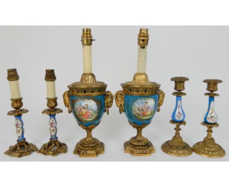 A PAIR OF SEVRES STYLE URN LAMPS painted with courting couples and flowers, with ormolu rams mask handles, 34cm high, togethe