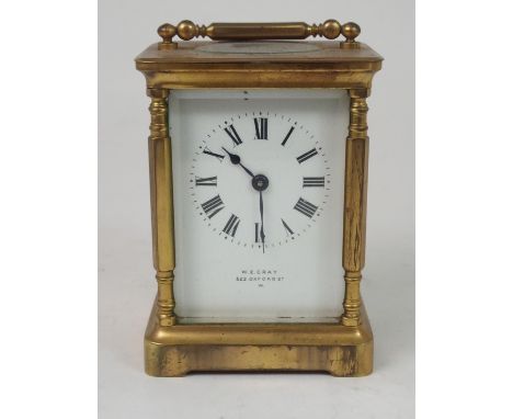 A FRENCH BRASS AND GLASS CARRIAGE CLOCK the white enamel dial with Roman Numerals, retailed by W.E. Gray, 522 Oxford Street W