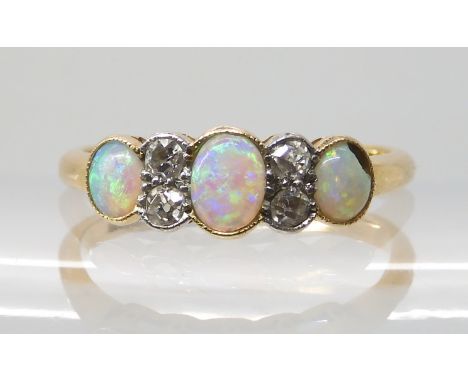 AN 18CT OPAL AND DIAMOND RING the gems are set into a millgrained tubed galleried mount, the central opal is approx 5mm x 4mm