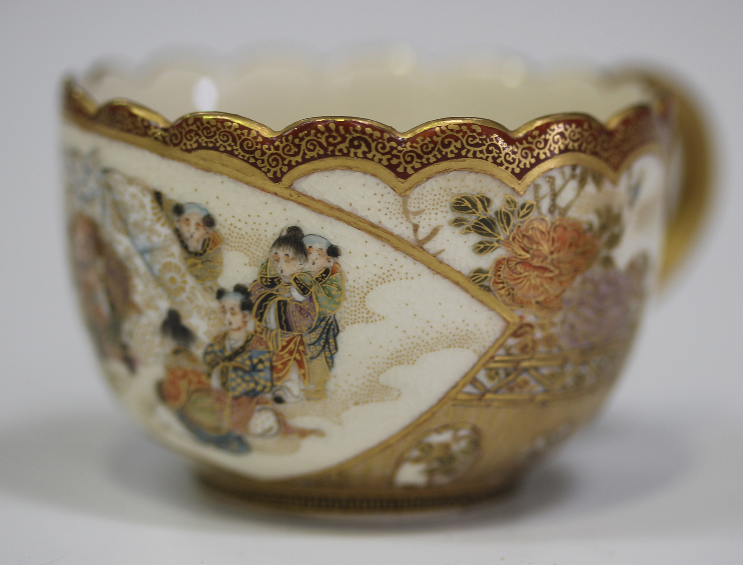A Japanese Satsuma earthenware cup and saucer by Kaizan, Meiji
