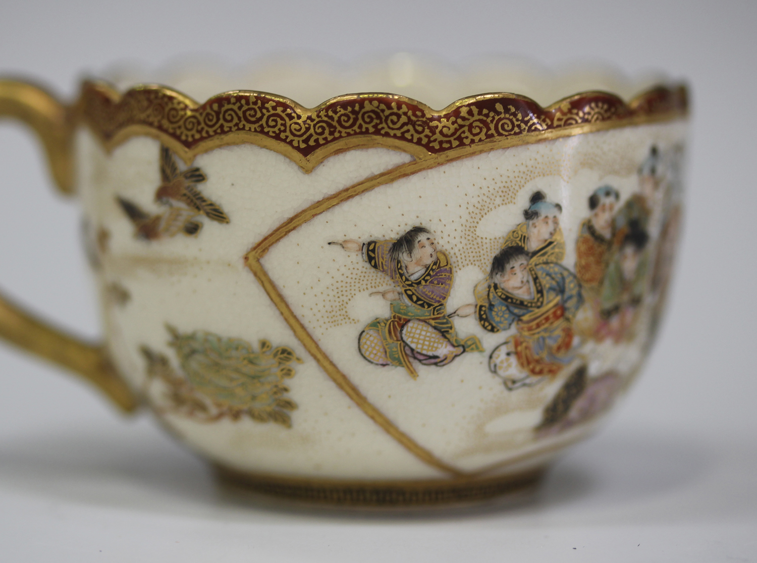 A Japanese Satsuma earthenware cup and saucer by Kaizan, Meiji