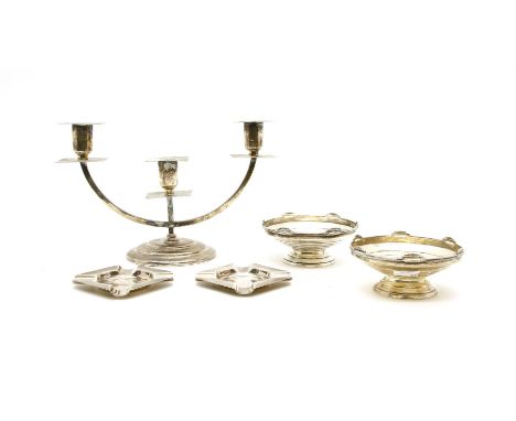 An Art Deco silver three branch candelabra, the angular sconces on crescent form branch and stepped circular base, Birmingham