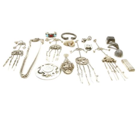 A collection of oriental silver coloured items, to include four chatelaines, a dish, five ingots, a chain with dragon heads, 