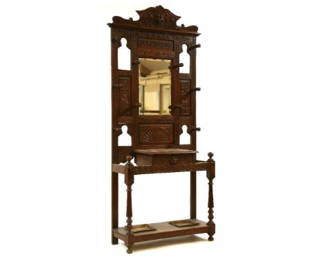 A Victorian carved oak hallstand, having central mirror above glove box with profuse mask and foliate decoration, 91cm wide, 