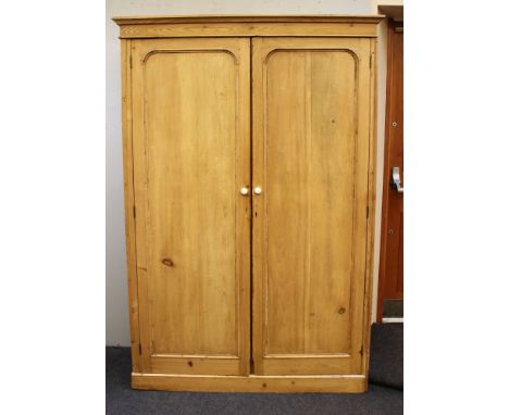 A Victorian pine two door wardrobe, with ceramic handles, 138cm wide, 55cm deep, 203cm