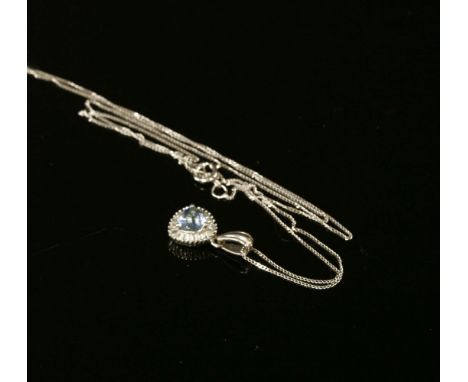 A white gold aquamarine and diamond cluster pendant, a trilogy cut aquamarine claw set to a border of step cut diamonds, susp