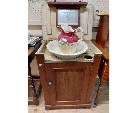 A 56cm Victorian stained oak washstand with internal mirror top lift-top and panelled cupboard door under, complete with an a