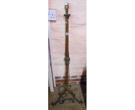 An early 20th Century cast brass standard lamp of column form with acanthus leaf decoration, set on three Rococo scroll feet 