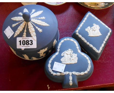 Three pieces of Wedgwood dark blue jasperware comprising circular lidded box and two similar playing card shape suite shaped 