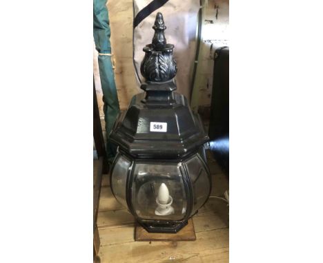 A large lamp of post top streetlamp form with bevelled effect perspex panels and black painted finish cage, set on a wooden b