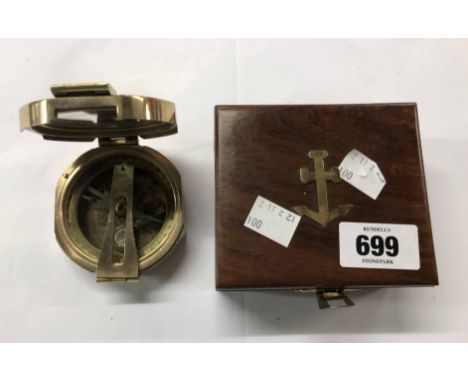 A modern nautical style compass in lift-top wooden box