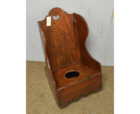 A Georgian mahogany child's rocking commode, the raised shaped back with pierced heart motif, 66cms high.