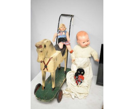 A selection of vintage toys, including two dolls and a vintage push-along horse, possibly Tri-Ang.