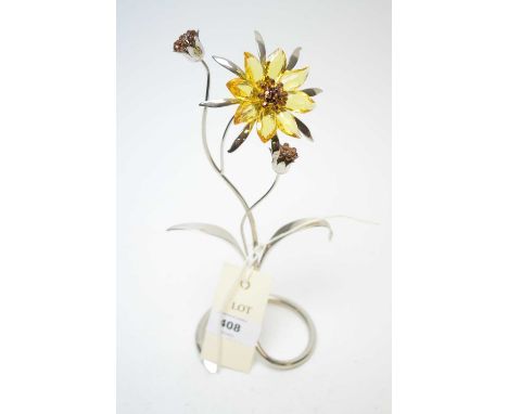 A Swarovski Crystal Paradise Flower 'Darigold Light Topaz', raised on a foliate metal base.