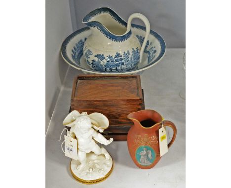 A Victorian ceramic spill vase, likely by Moore Bros, formed as a figure of a cherub, with floral encrusted sack upon his bac