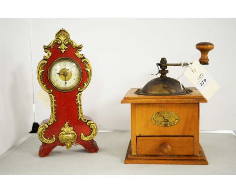 A vintage coffee grinder, by Peugeot Freres, Valentigney; together with a miniature mantel clock, by Fisher Strand.  (2)