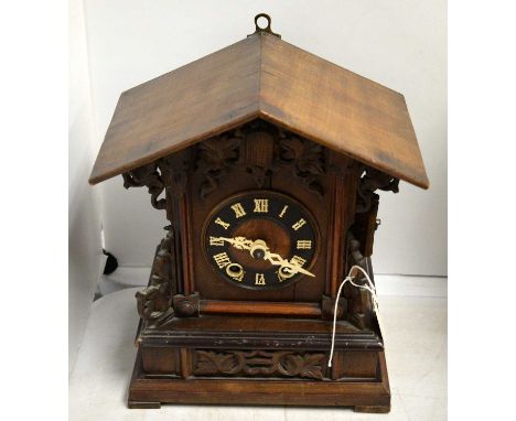An American mahogany mantel clock, the architectural case with applied carved scrolling leaf design, raised on bracket feet, 