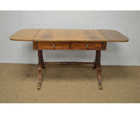 A Regency mahogany and brass inlaid sofa table, the rectangular double-flap top above two frieze drawers, opposed by two dumm