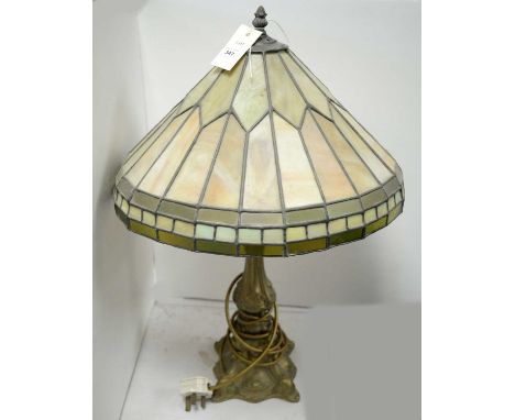 A 20th Century Tiffany style table lamp, with leaded stained glass shade over a tapered gilt metal base, 65cms high.