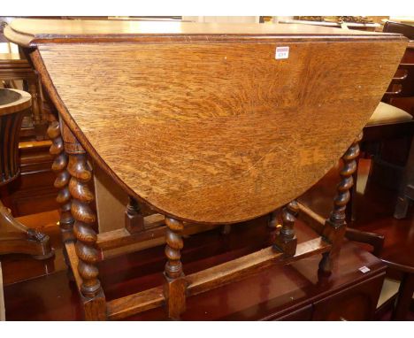 A 1920s barley twist oak drop leaf table, having a gate leg action