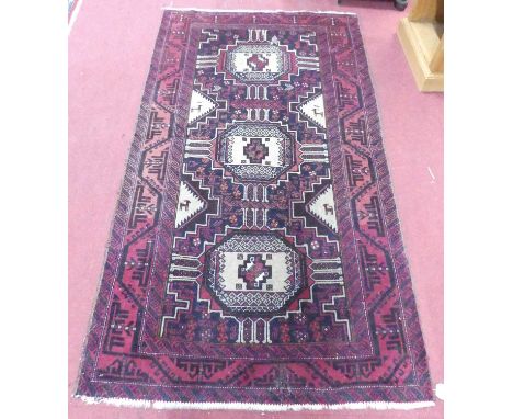 A Persian woollen red ground Bokhara rug, 190 x 105cm