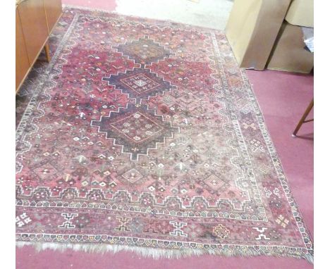A Persian woollen red ground Heriz rug, 295 x 216cm