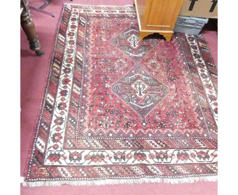 A Persian woollen red ground Shiraz rug, 212 x 172cm