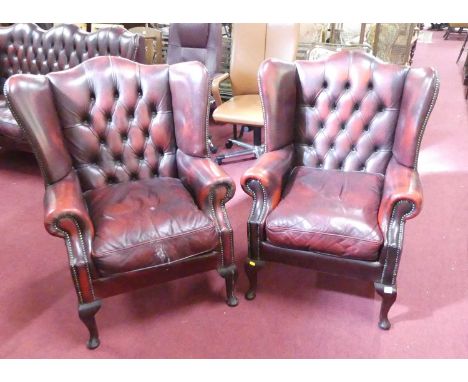 A reproduction buttonback red-wine leather upholstered three-piece wingback suite, comprising; a three-seater settee and a pa