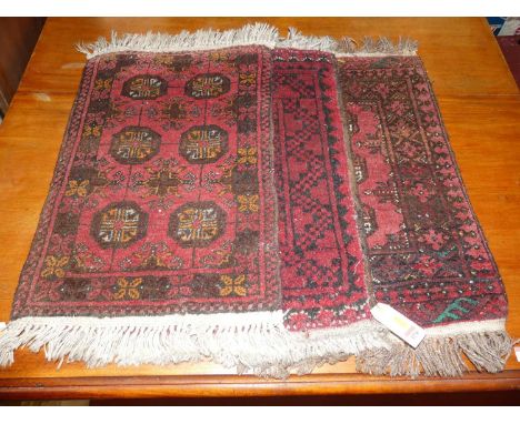 Three Persian red ground woollen Bokhara hall rugs, each approx 65 x 45cm